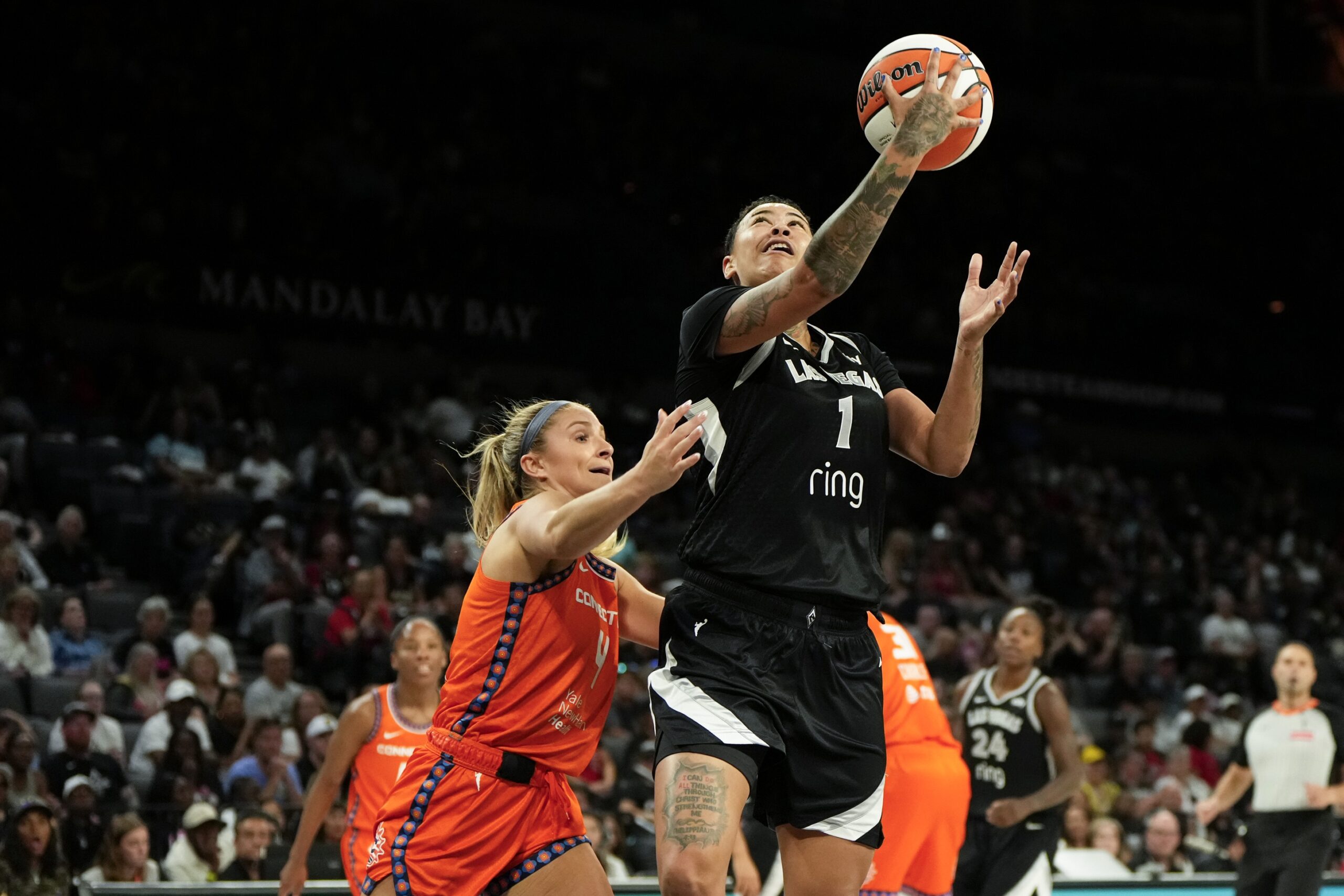 Kierstan Bell drives for a layup for the Las Vegas Aces against Jacy Sheldon and the Connecticut Sun at Michelob Ultra Arena.