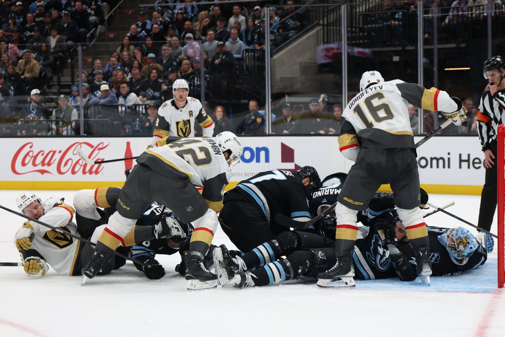 Players from the Utah Mammoth and Vegas Golden Knights battle in a pileup for the puck in front of the net during the second period at Delta Center on November 24, 2025.