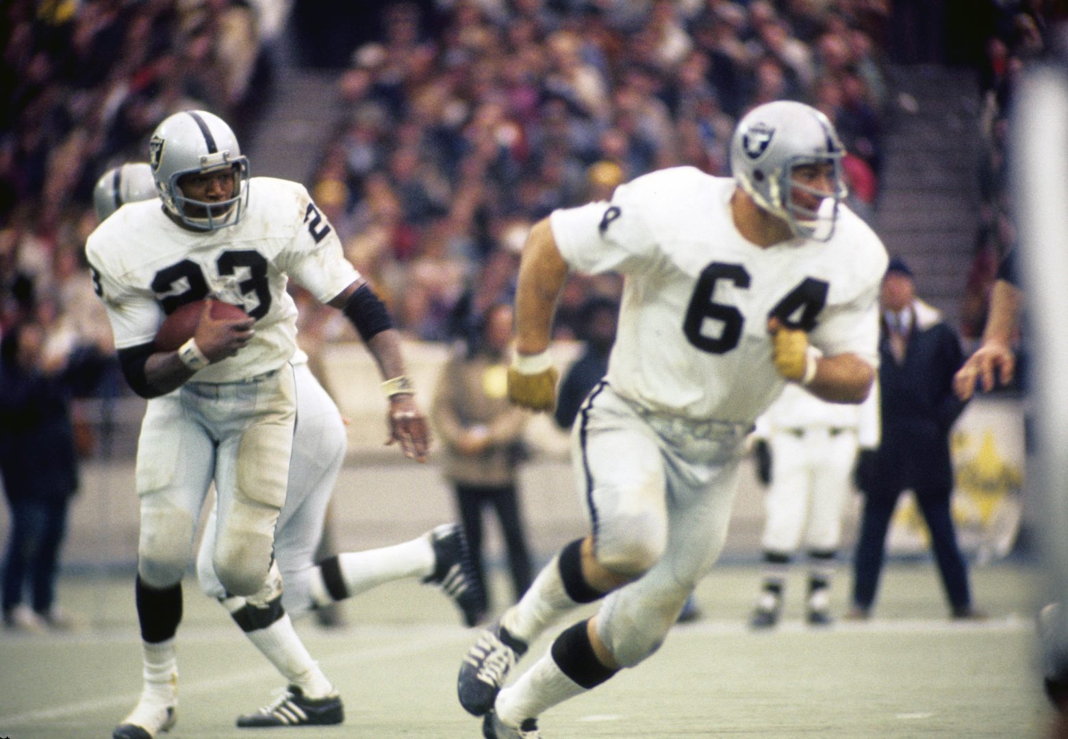 File photo: Oakland Raiders guard George Buehler (64) blocks as running back Charlie Smith (23) runs against the Pittsburgh Steelers at Three Rivers Stadium.