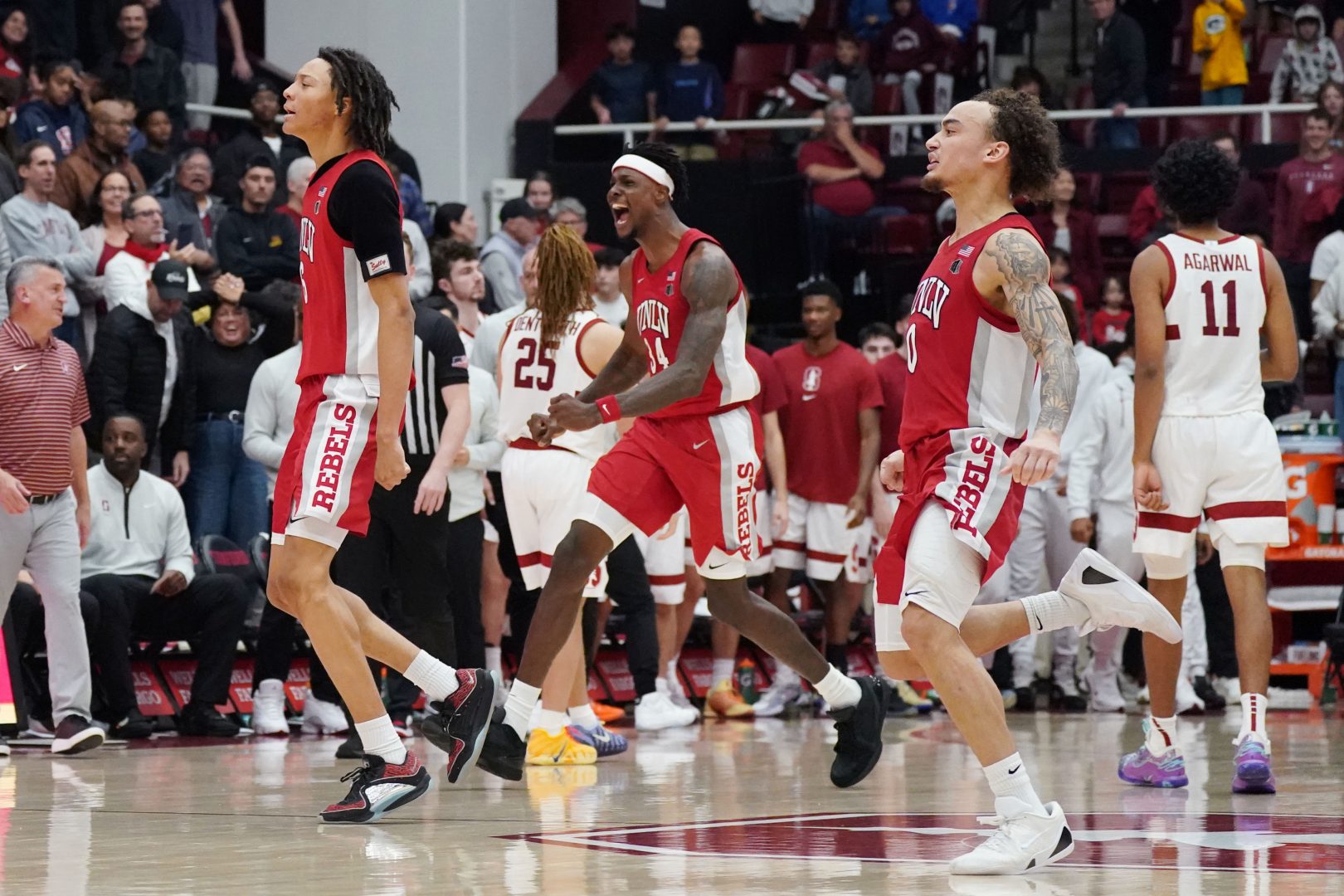 UNLV Runnin' Rebels forward Tyrin Jones (6), center Emmanuel Stephen (34), and guard Dra Gibbs-Lawhorn (0) celebrate at the end of the game against as Stanford Cardinal guard Ryan Agarwal (11) and the Stanford Cardinal leave the court at Maples Pavilion.