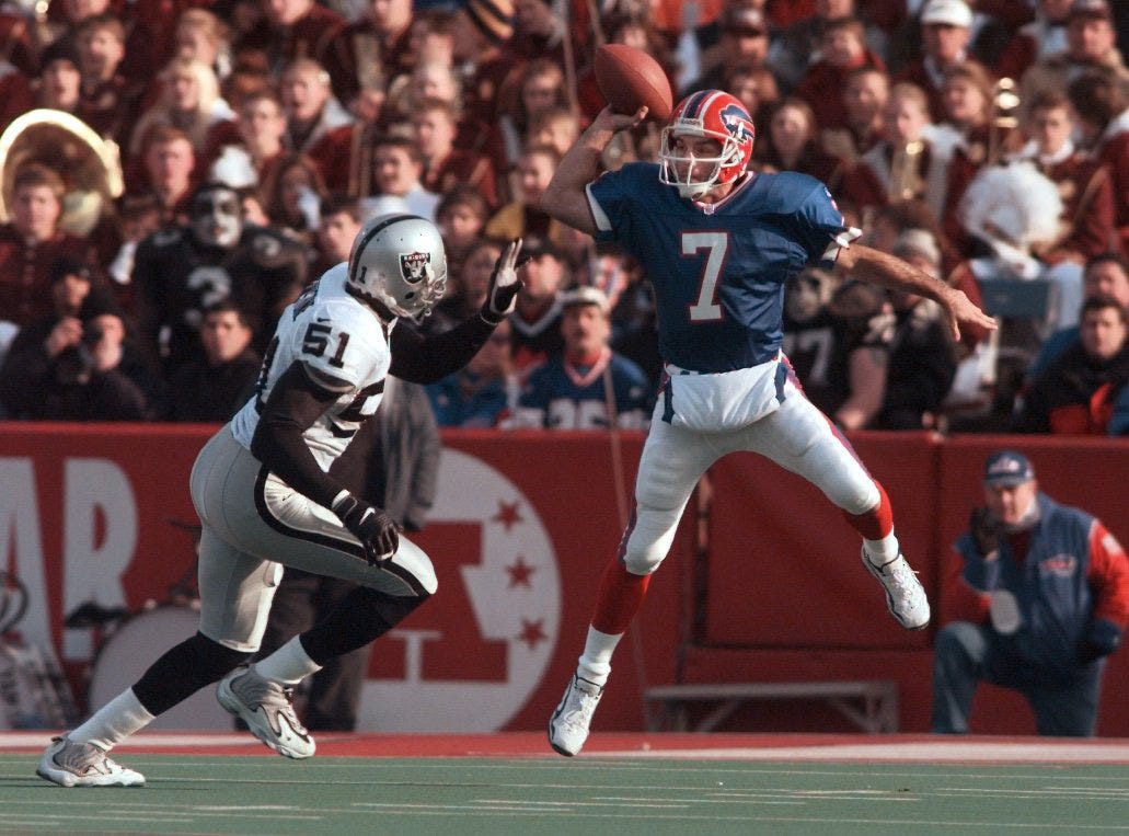 File photo: Buffalo Bills quarterback Doug Flutie leaps to throw over Oakland Raiders linebacker Lance Johnstone (51) during a game.
