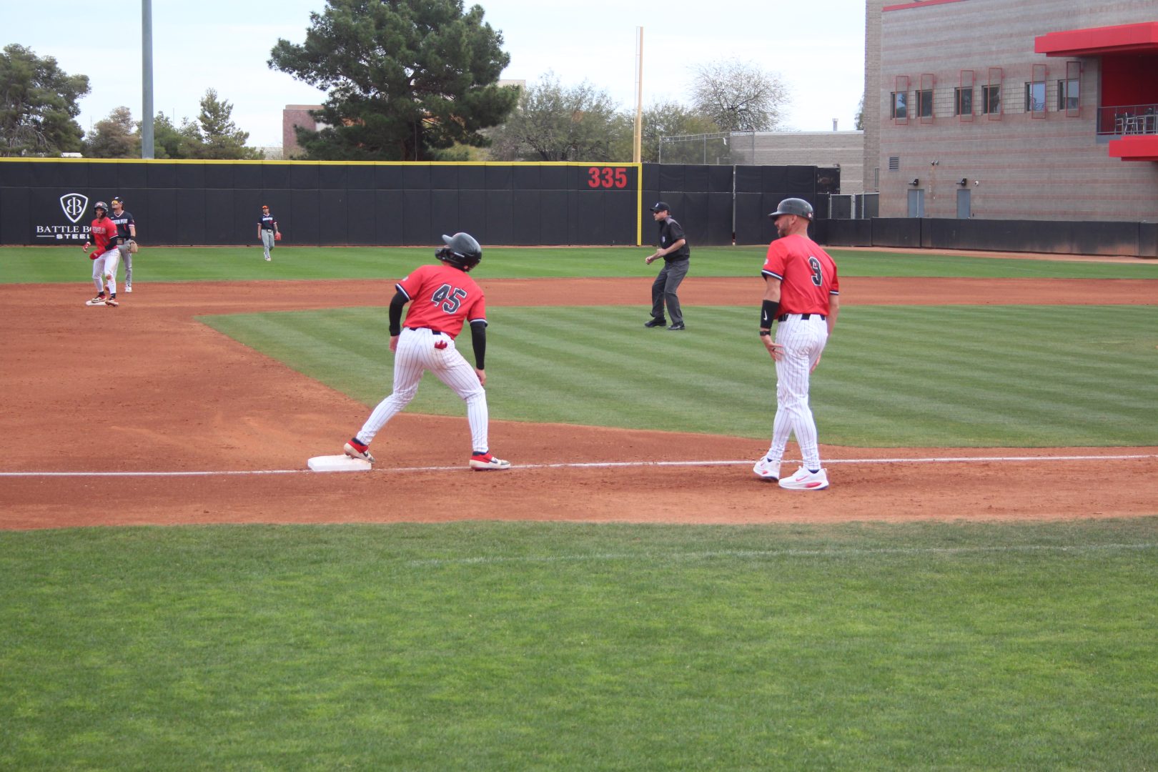 UNLV runner Connor Tallakson leads off third base, preparing to tag up and score.