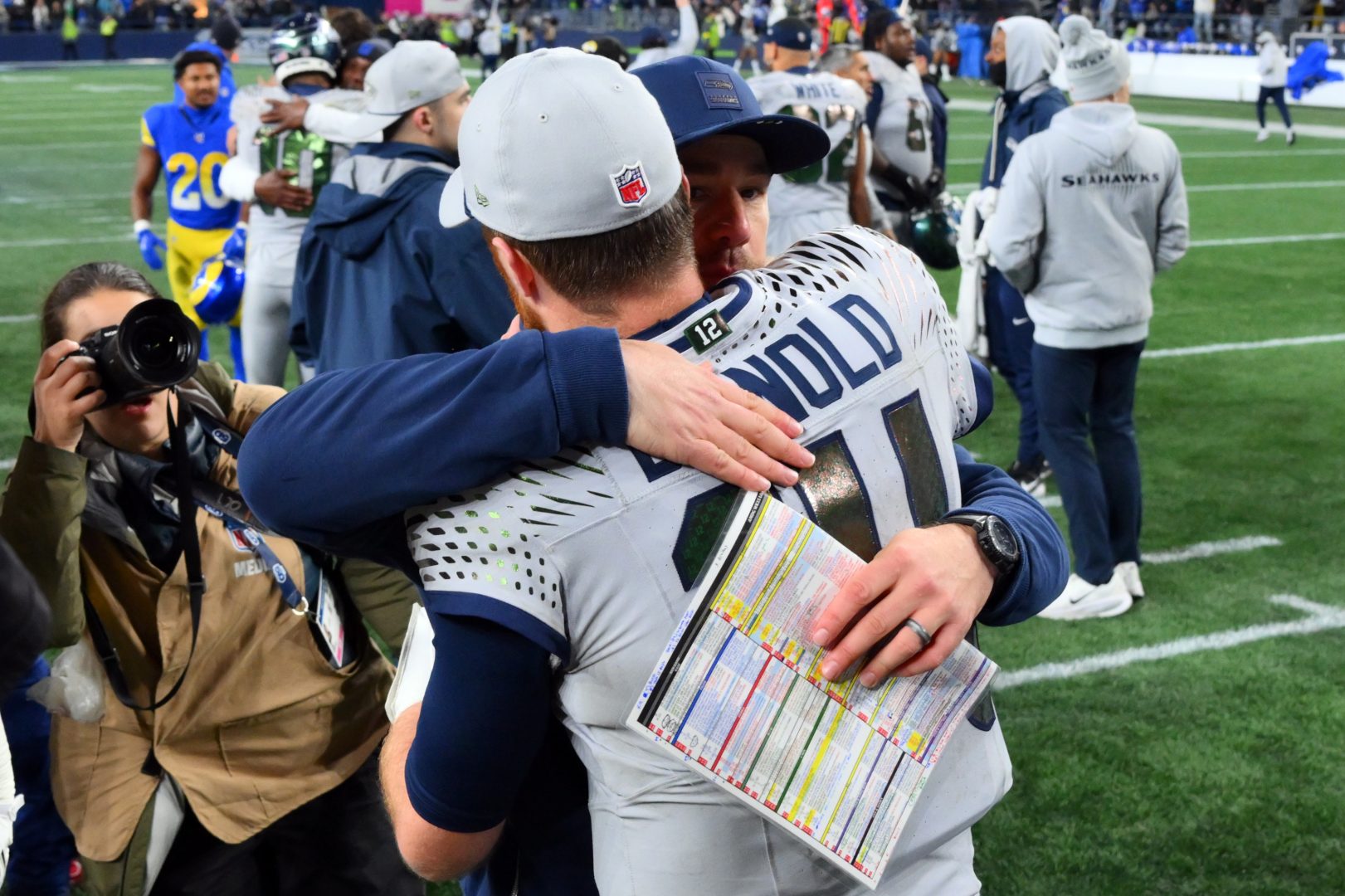 Seattle Seahawks offensive coordinator Klint Kubiak hugs quarterback Sam Darnold on the field after a 2025 NFL game