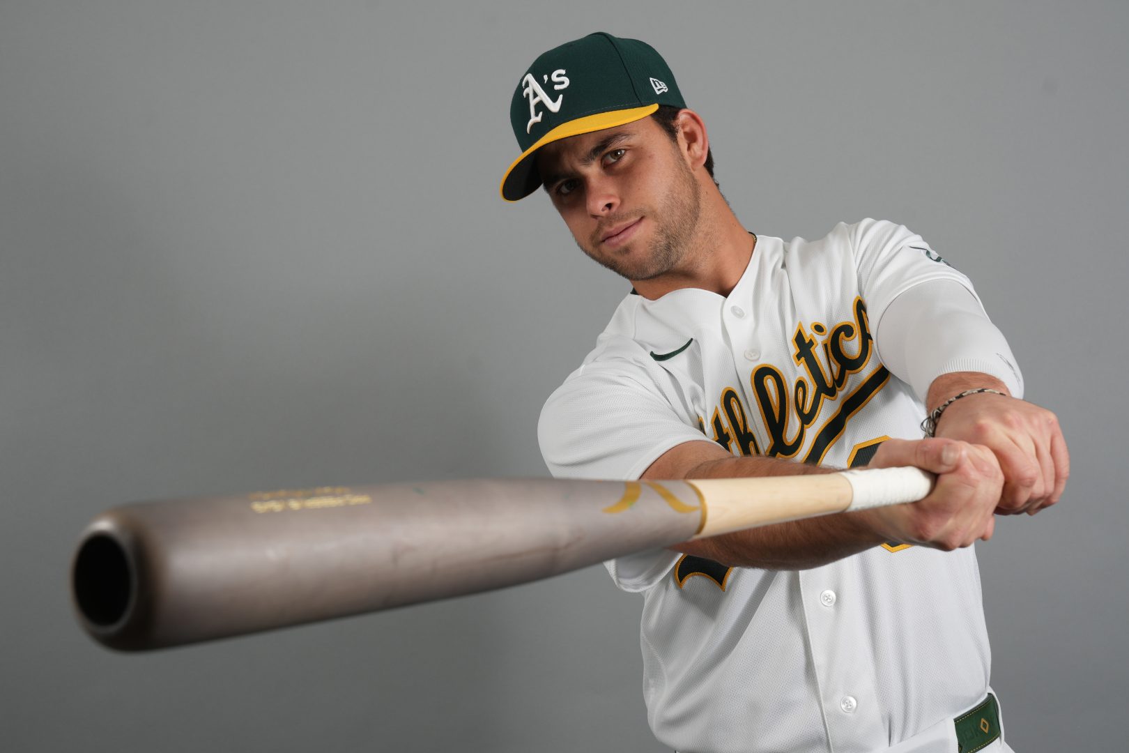 Athletics third baseman Max Muncy poses with a bat during photo day at Hohokam Stadium in Mesa, Arizona.