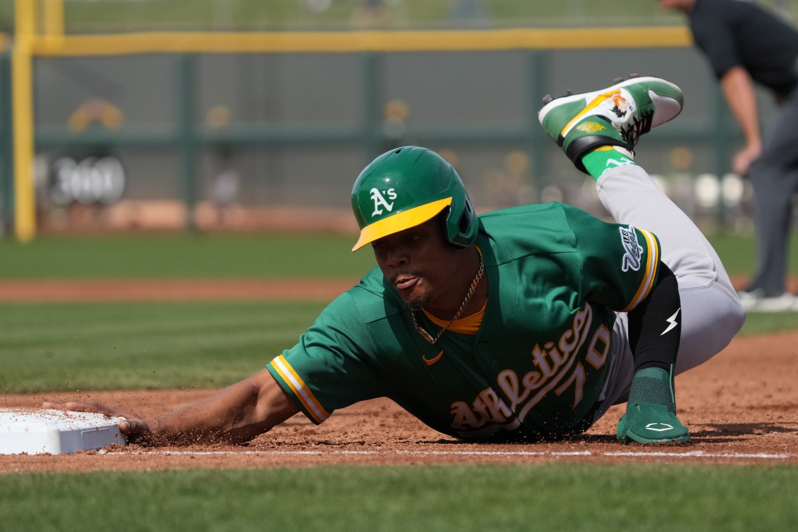 Athletics center fielder Junior Perez dives back to first base in the first inning against the Giants at Scottsdale Stadium.