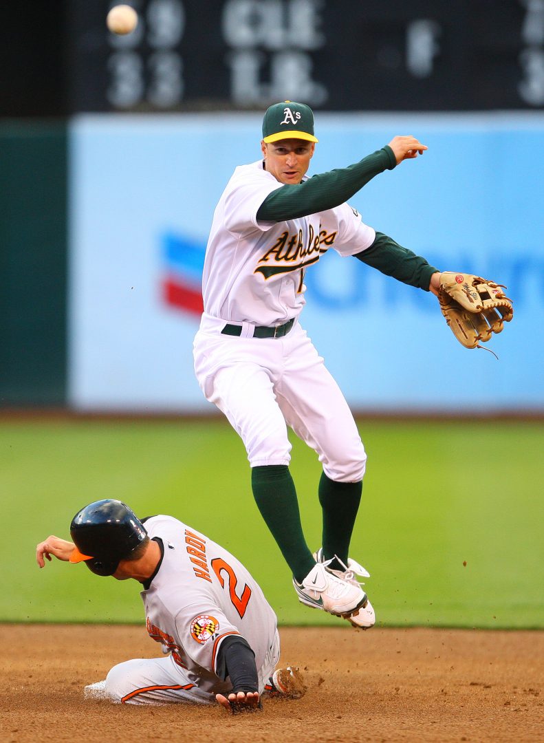 Athletics second baseman Mark Ellis completes a double play as Orioles runner J.J. Hardy slides into second base at Oakland-Alameda County Coliseum in Oakland.