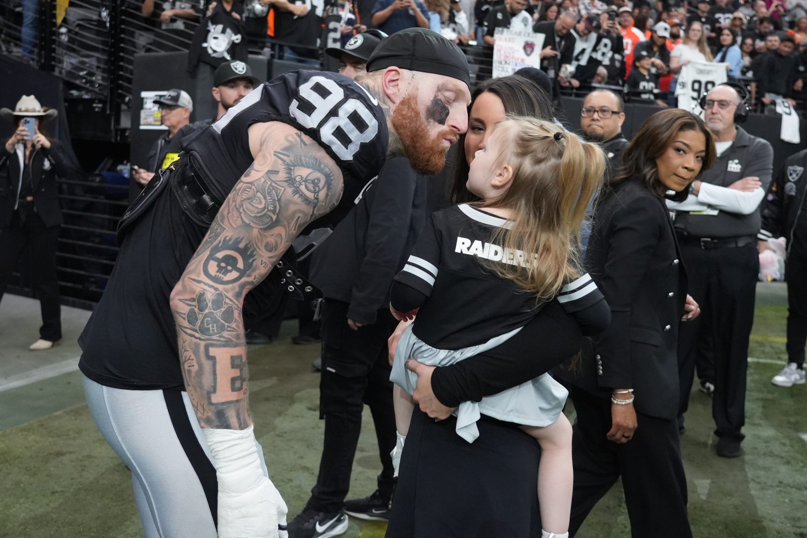 Raiders defensive end Maxx Crosby (98) greets his wife, Rachel Washburn, and daughter, Ella Rose Crosby, after receiving the Walter Payton Man of the Year Award at Allegiant Stadium.