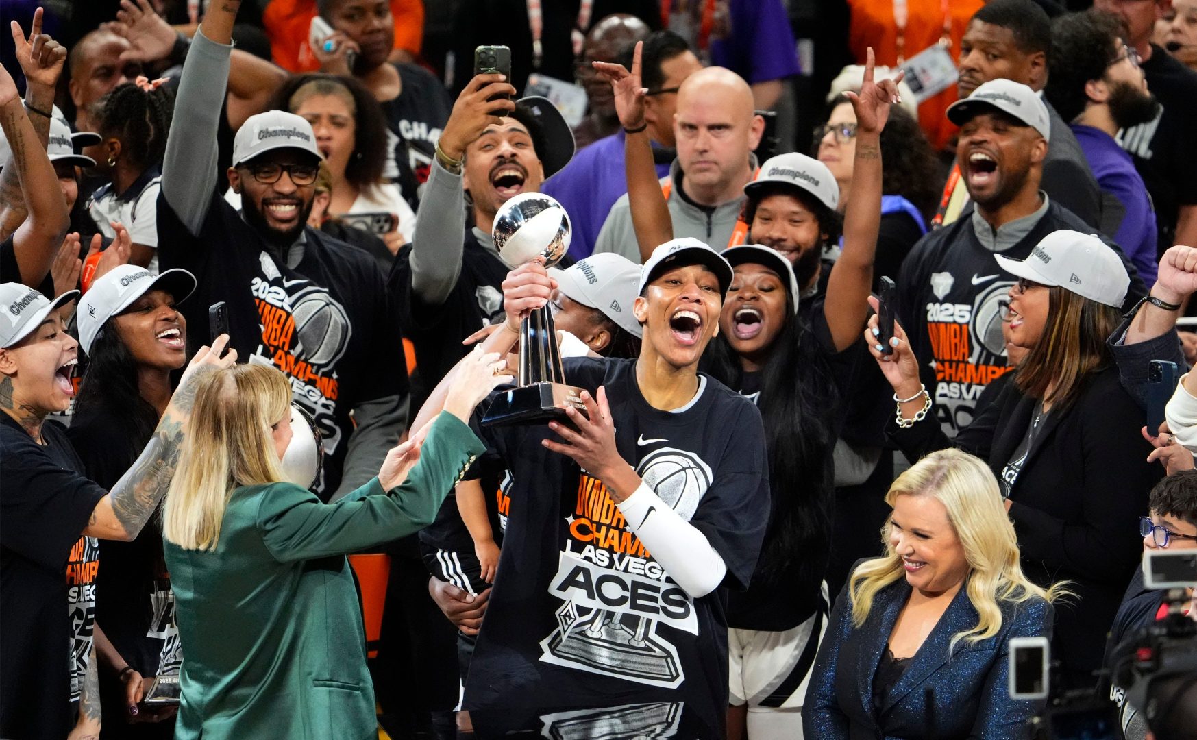 A’ja Wilson holds the Finals MVP trophy and celebrates on the court after the Aces clinch the 2025 WNBA title in Phoenix.