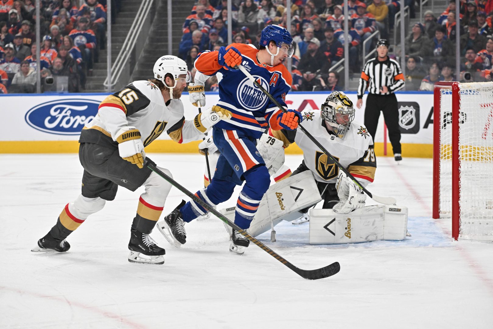 Vegas Golden Knights defenseman Noah Hanifin battles Edmonton Oilers center Ryan Nugent-Hopkins in front of goalie Carter Hart during the first period at Rogers Place on Dec. 21, 2025.