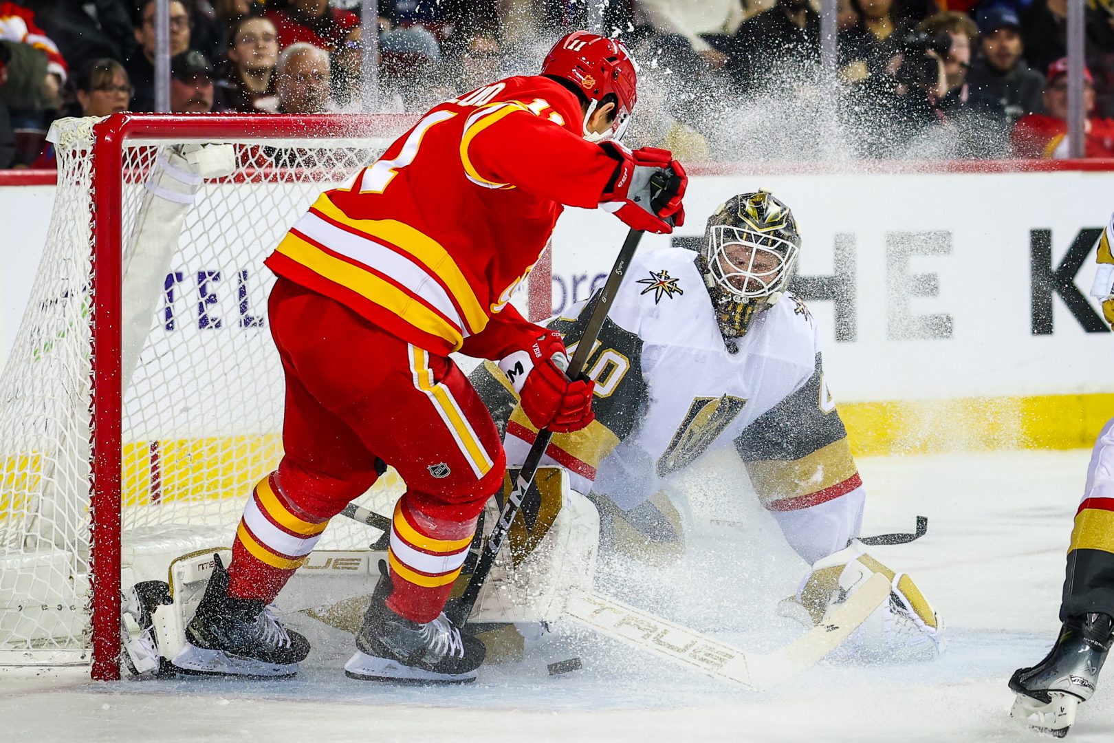 Calgary Flames center Mikael Backlund scores against Golden Knights goalie Akira Schmid during a Dec. 20, 2025 game at Scotiabank Saddledome.