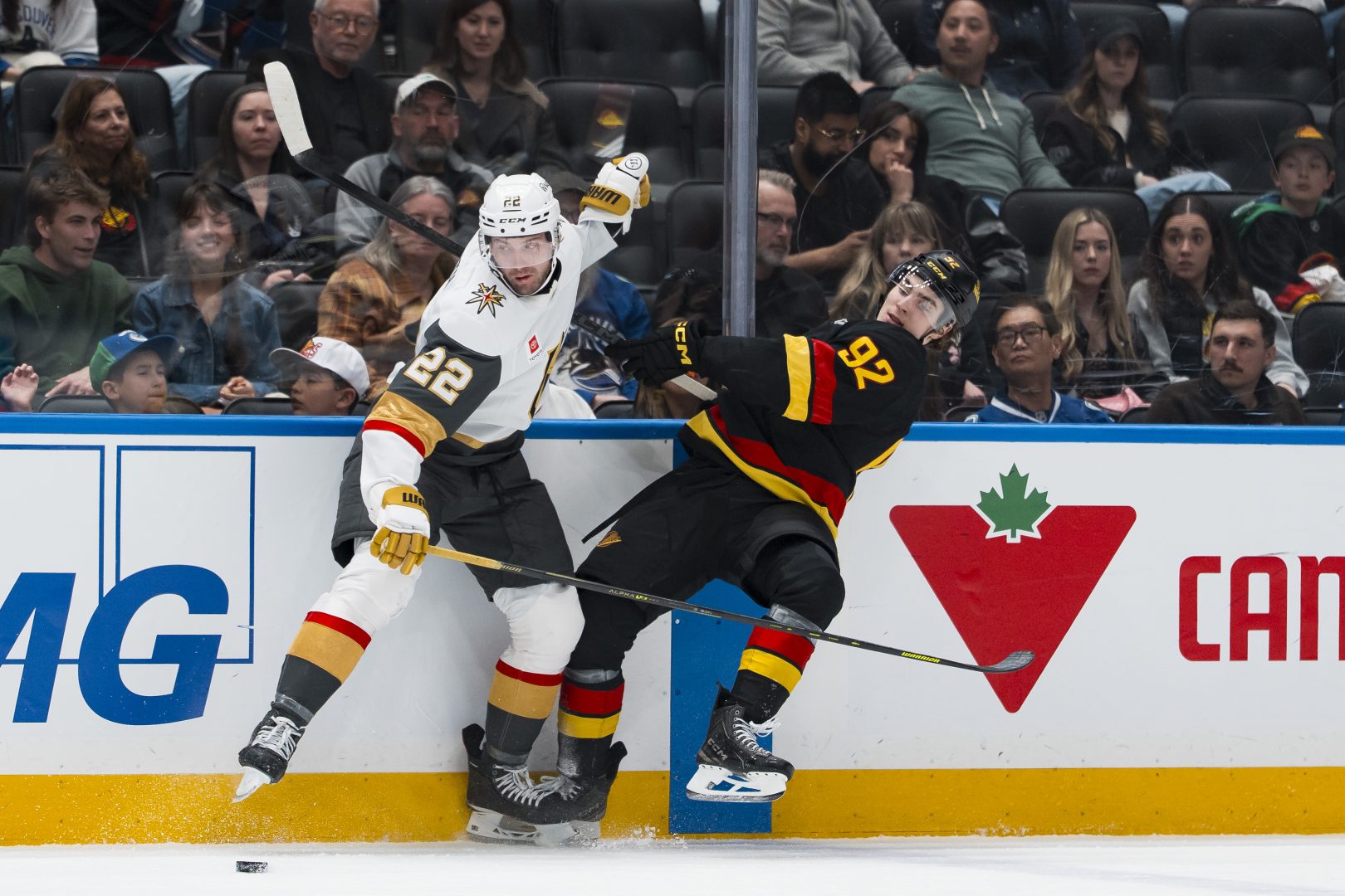 Cole Smith checks Liam Ohgren along the boards during third period play as the Golden Knights close out a road win over the Canucks at Rogers Arena.