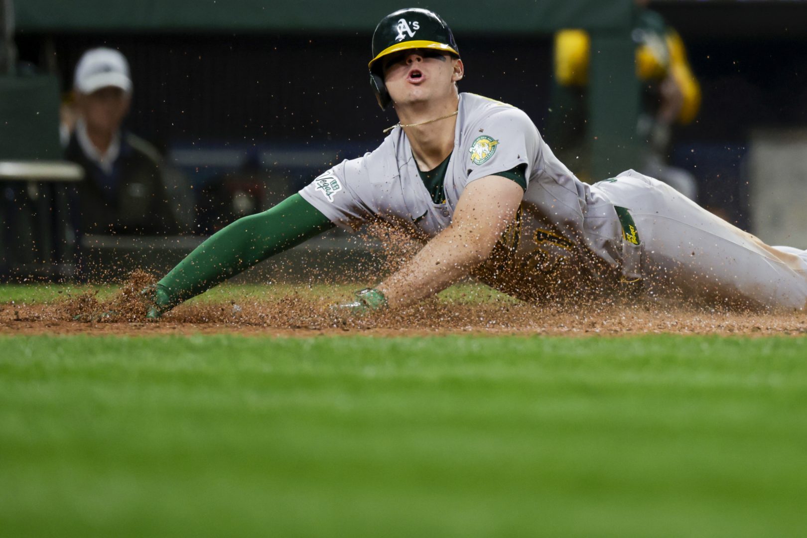 Tyler Soderstrom slides home safely ahead of catcher Cal Raleigh during the eighth inning against the Mariners on April 20, 2026, at T-Mobile Park
