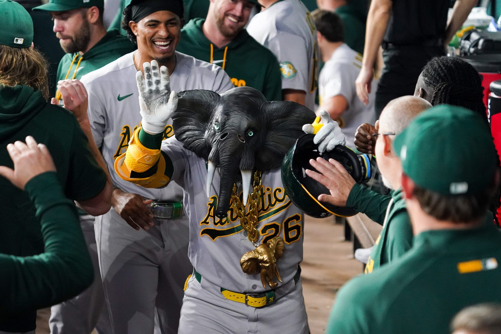 Carlos Cortes celebrates in the Athletics dugout with an elephant necklace and mask after hitting a first-inning home run against the Rangers.