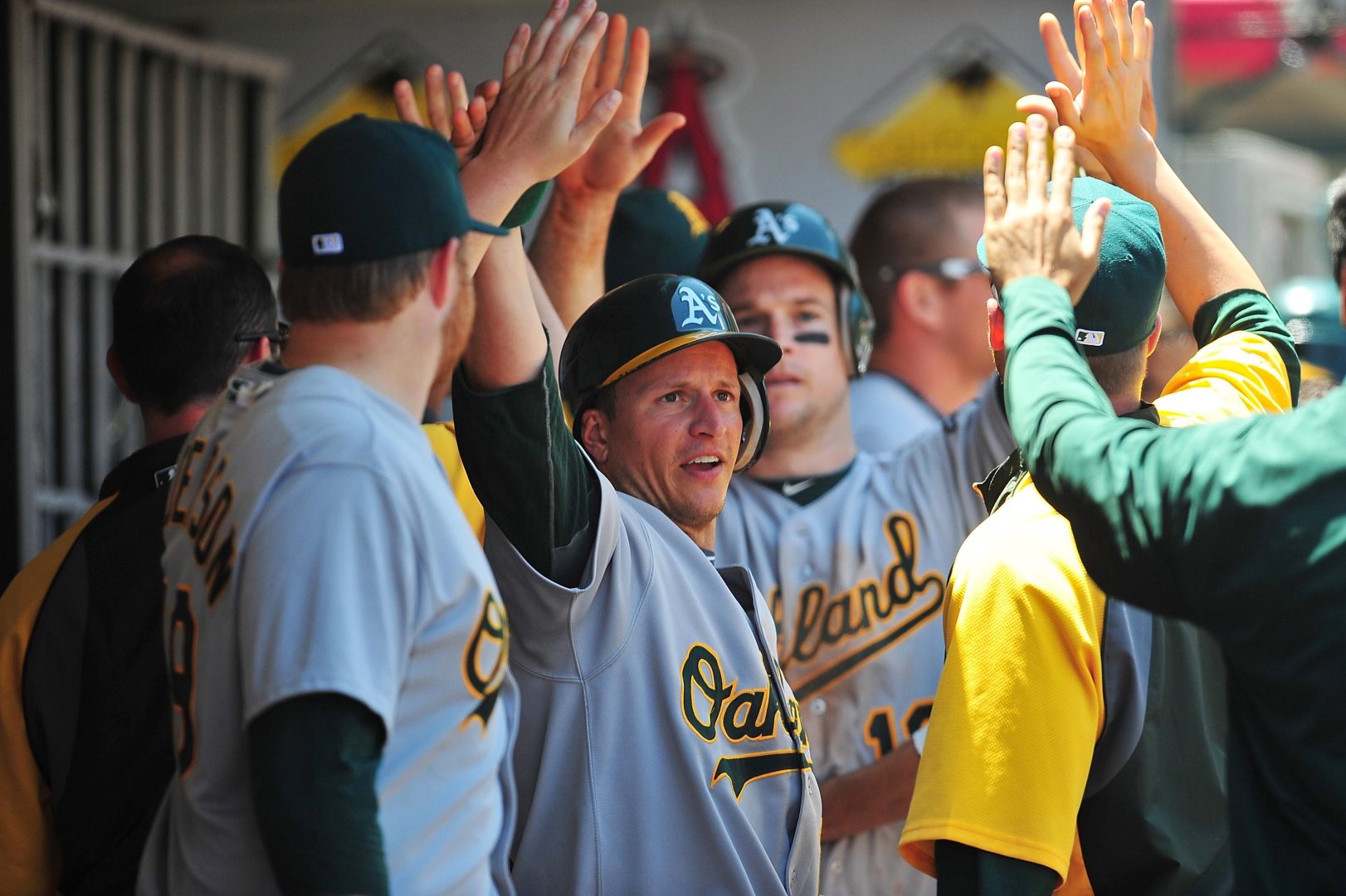 Mark Ellis celebrates in the dugout after scoring for the Oakland Athletics during a 2011 game against the Angels in Anaheim