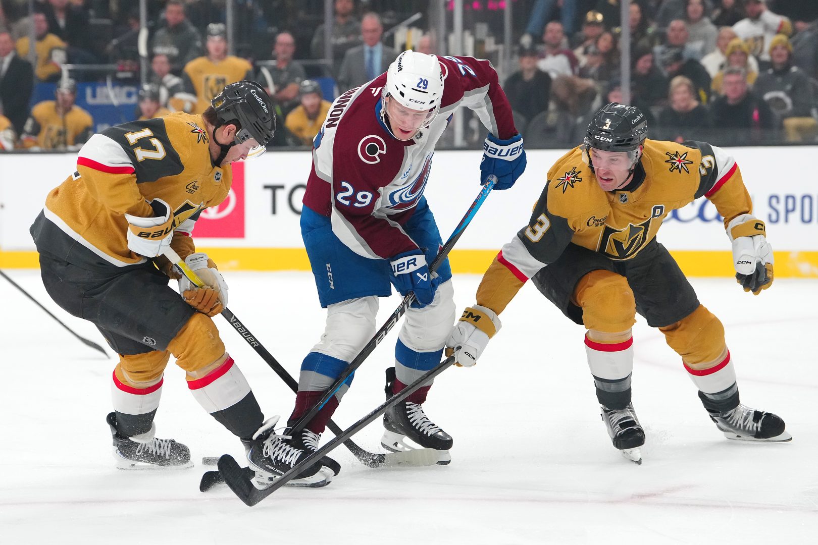 Nathan MacKinnon loses the puck between Ben Hutton and Brayden McNabb during a Golden Knights-Avalanche game at T-Mobile Arena.