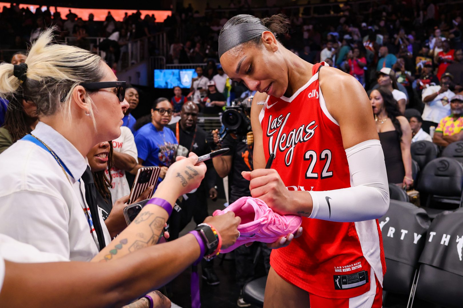 A’ja Wilson signs an autograph for a fan after a Las Vegas Aces road win against the Atlanta Dream.