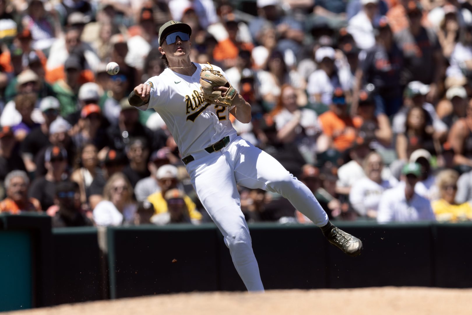 Athletics third baseman Zack Gelof leaves his feet to throw out Casey Schmitt at first base during the third inning at Sutter Health Park.