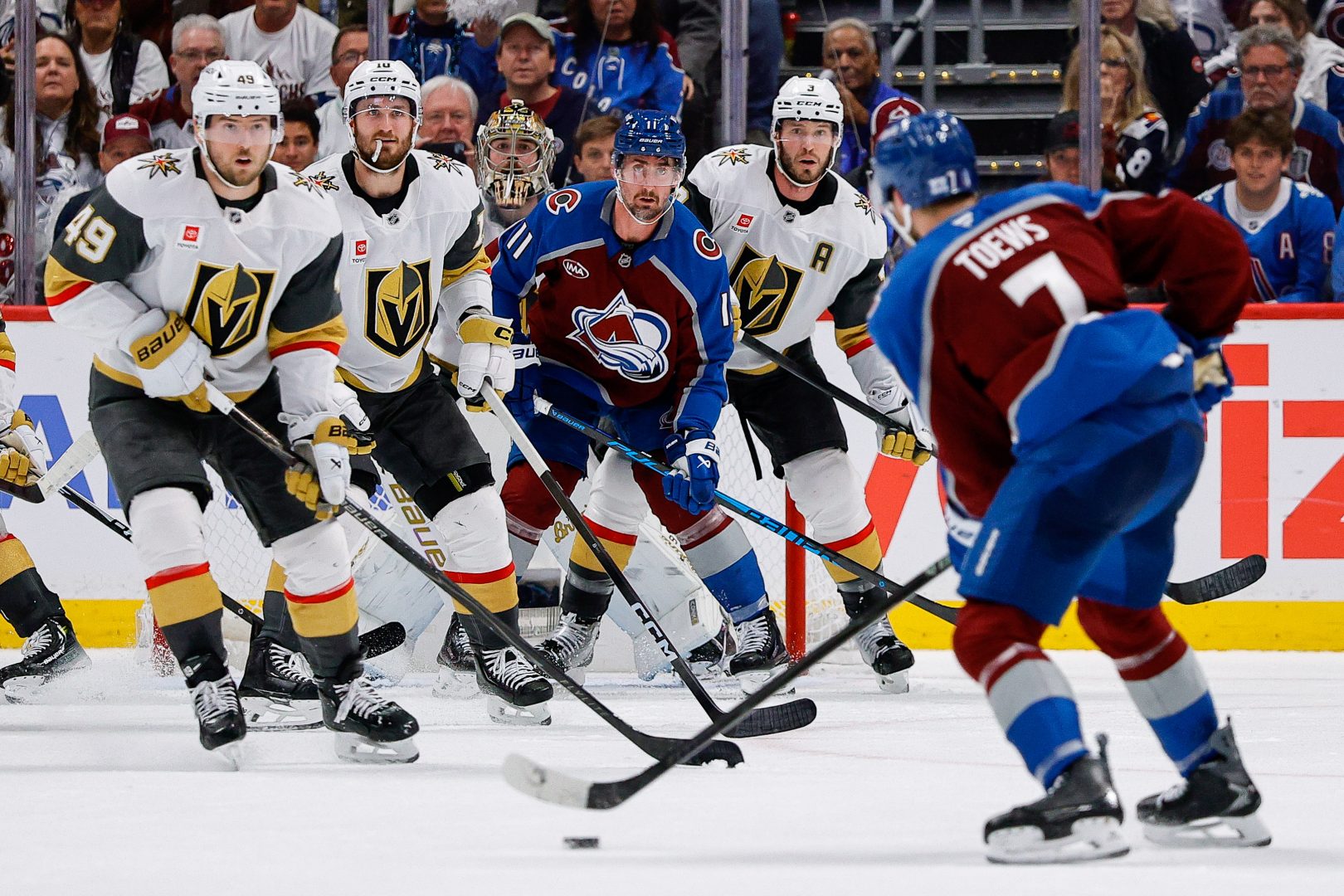 Devon Toews controls the puck as Ivan Barbashev, Colton Sissons, Brayden McNabb and Carter Hart defend in front of the Vegas net.