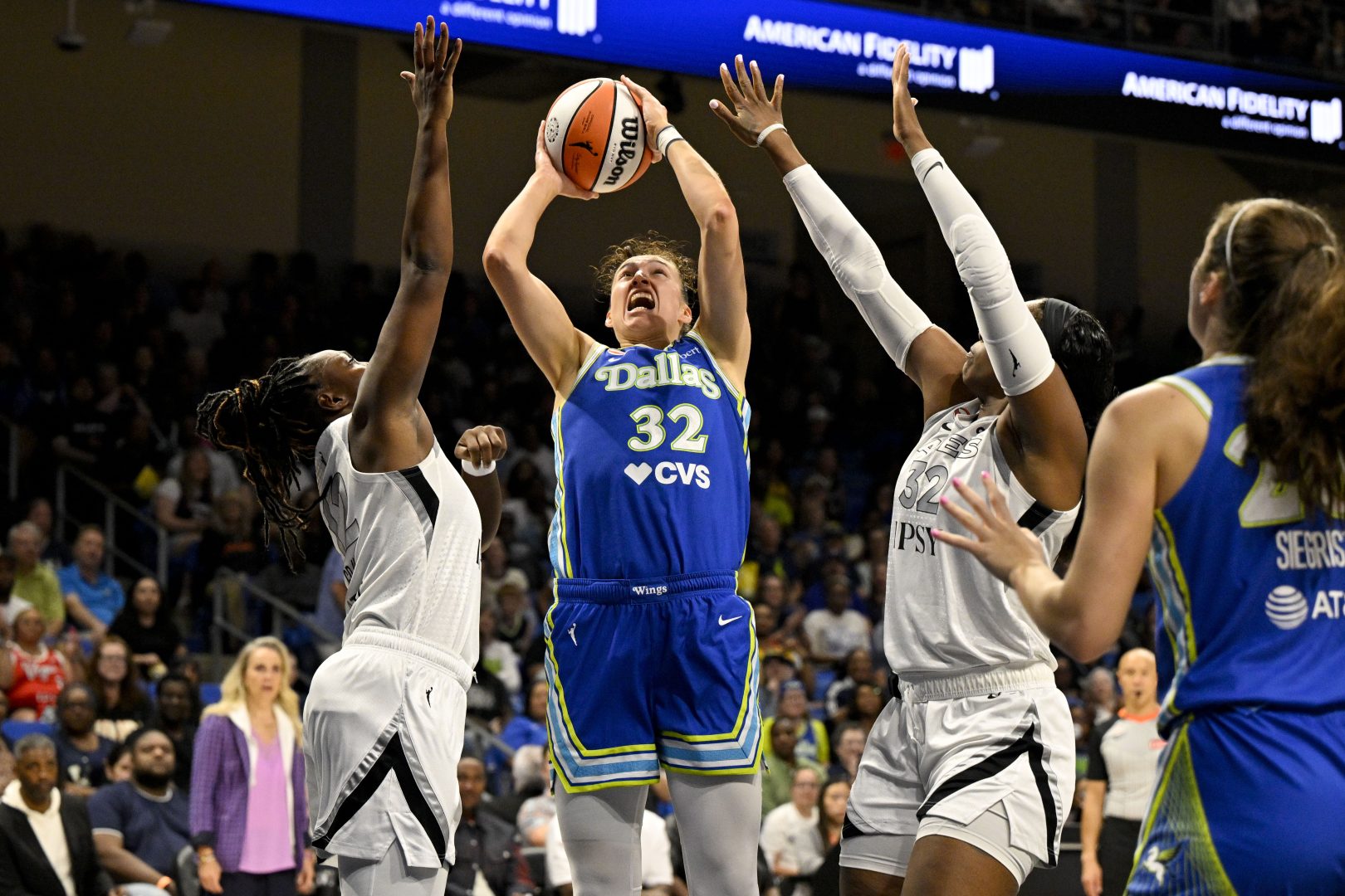 Dallas Wings forward Jessica Shepard shoots over Las Vegas Aces defenders Cheyenne Parker-Tyus and Chelsea Gray during a game at College Park Center.