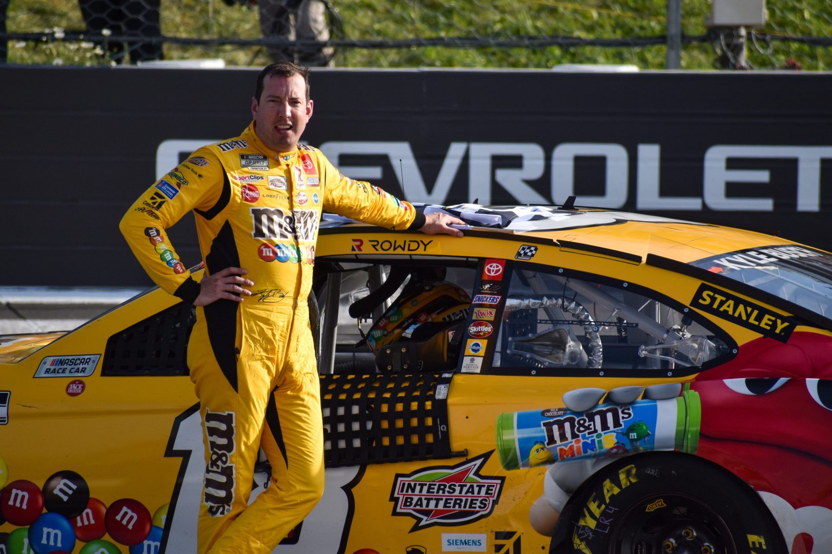 Kyle Busch poses with his No. 18 M&M's Toyota after winning