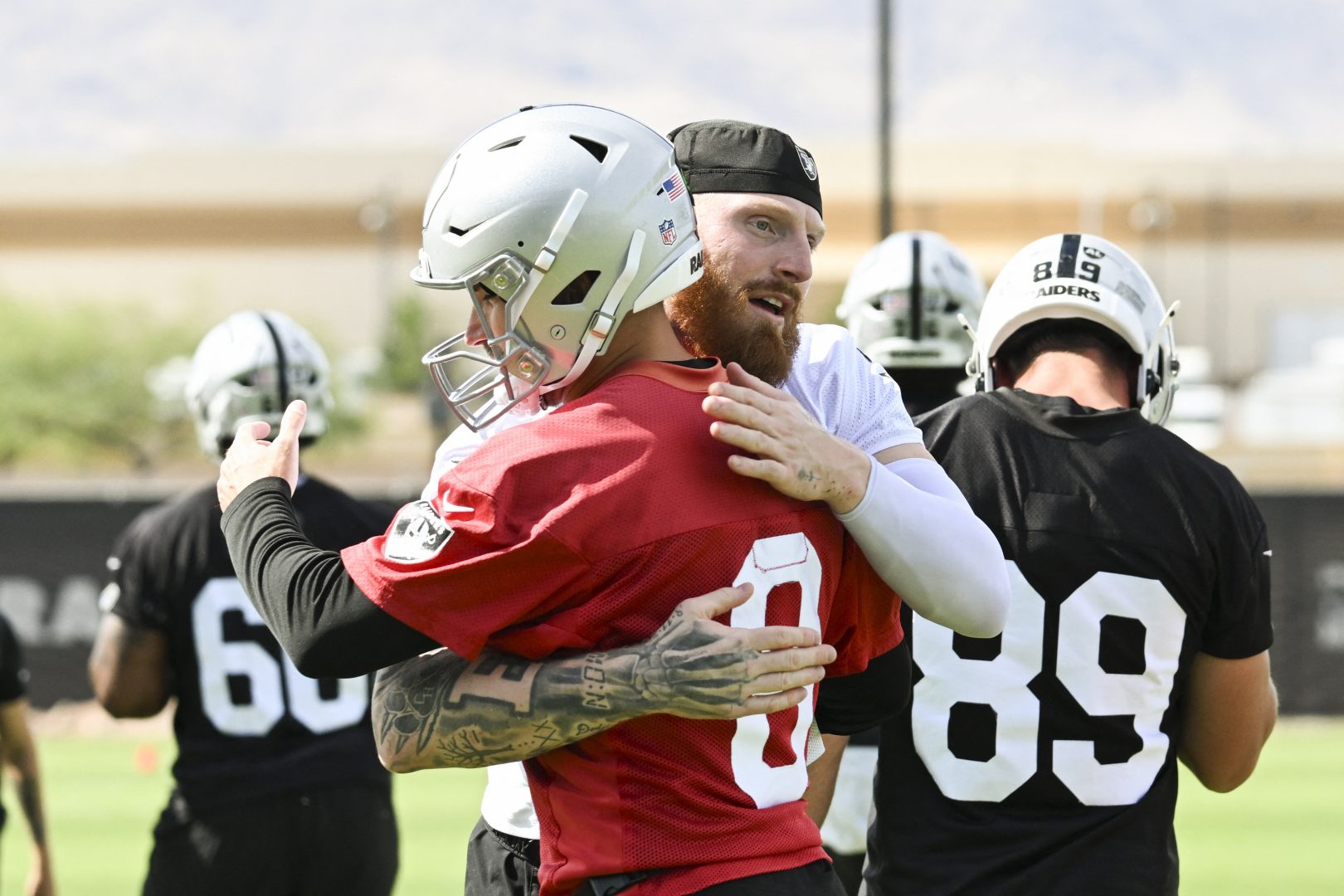 Maxx Crosby hugs Kirk Cousins during Raiders organized team activities in Henderson