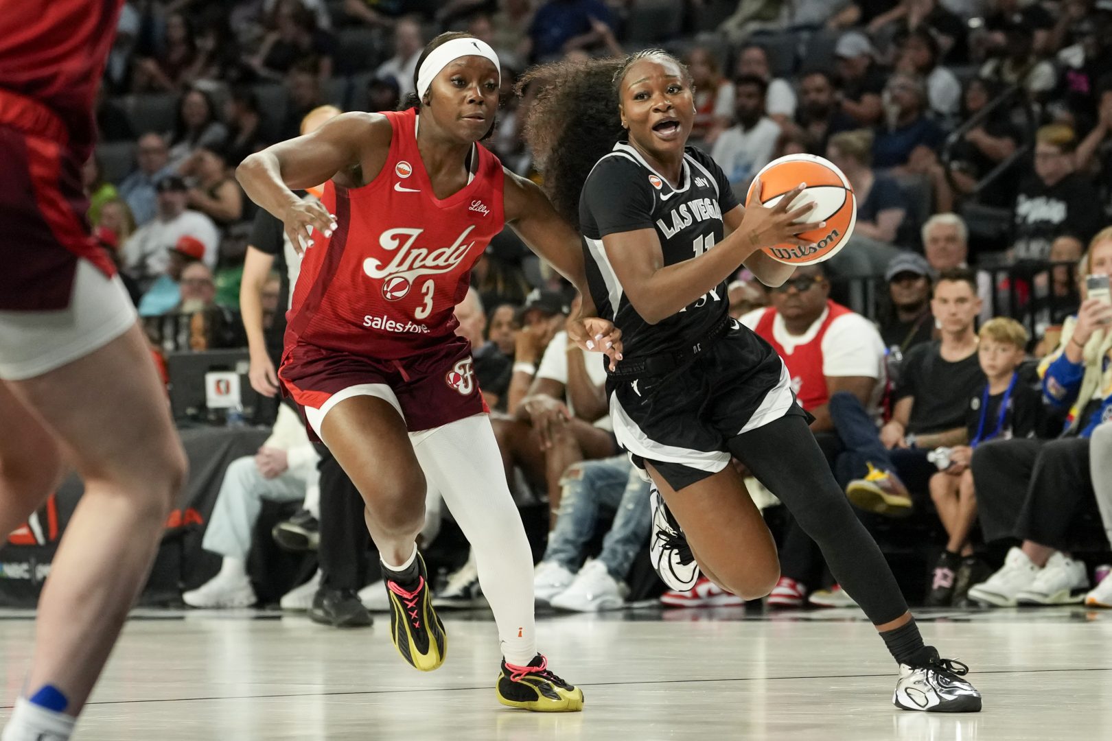 Las Vegas Aces guard Dana Evans drives past Indiana Fever guard Raven Johnson