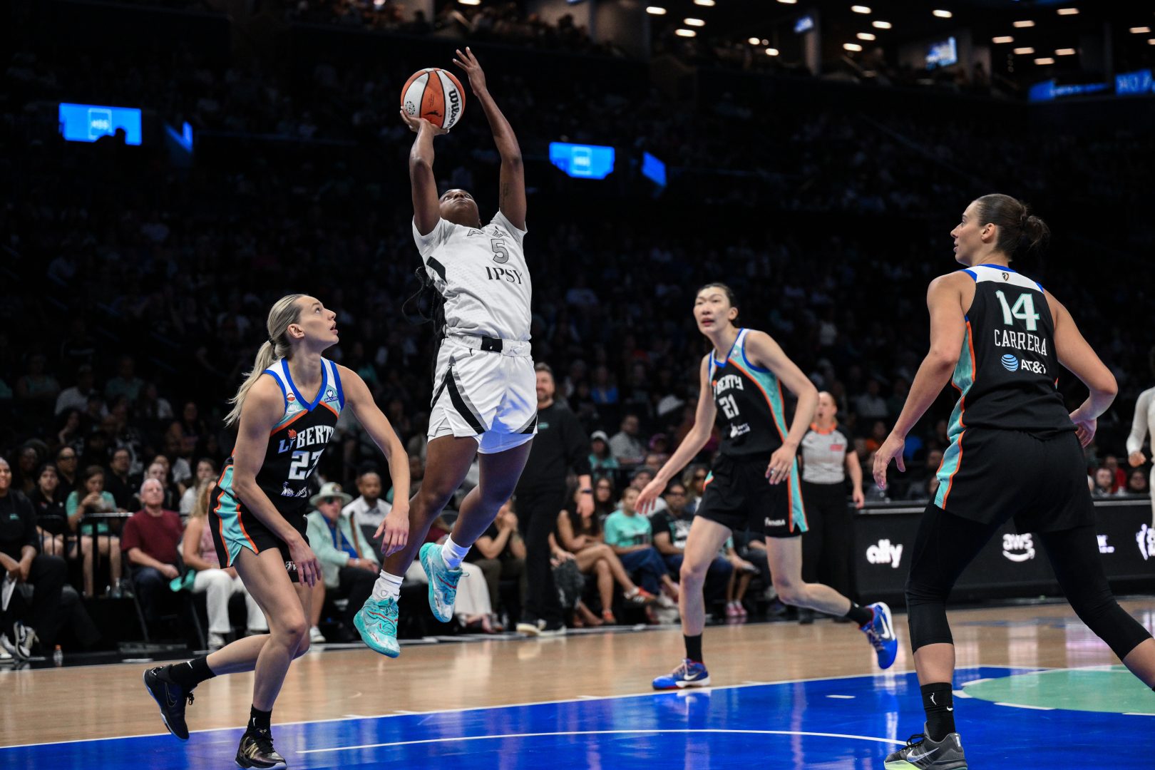 Las Vegas Aces guard Ta'Niya Latson shoots over New York Liberty guard Marine Johannes