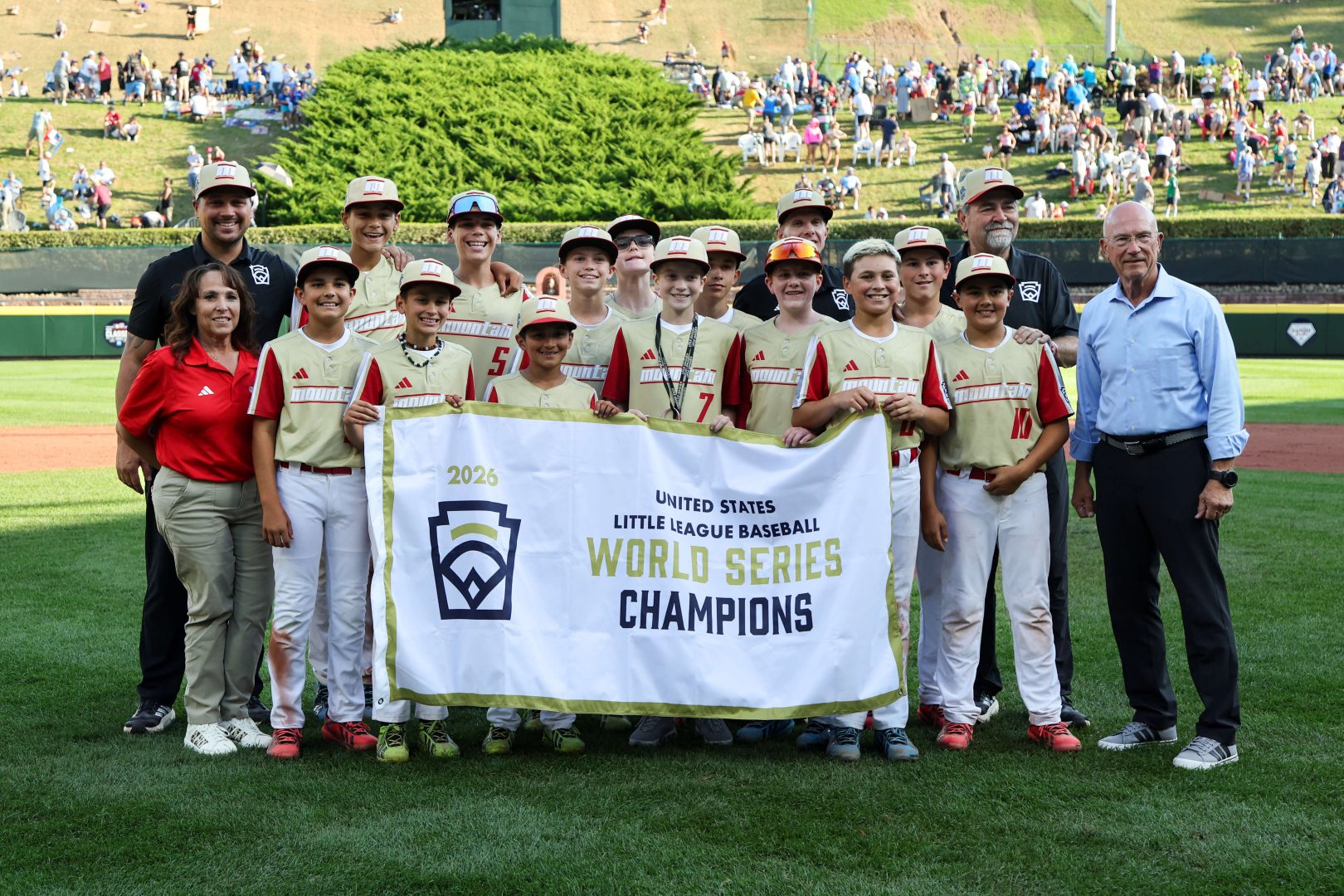 Paseo Verde Little League players and coaches pose with the United States Championship banner