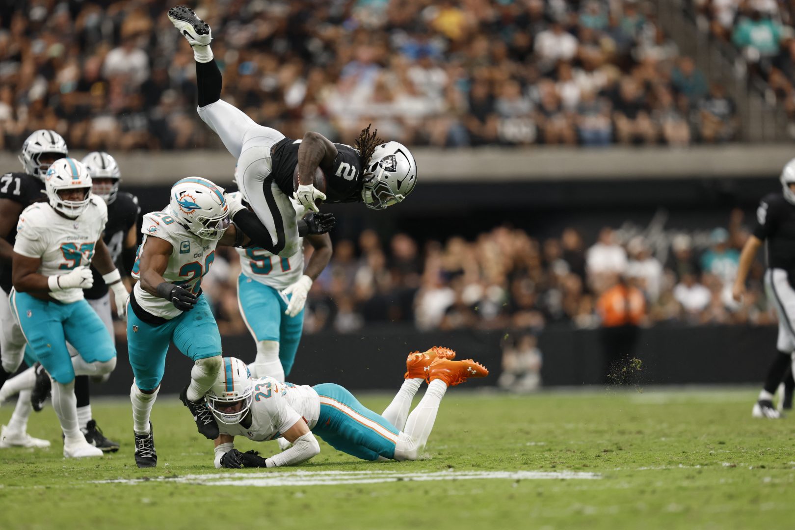 Raiders running back Ashton Jeanty fights through a tackle by Dolphins safety Zayne Anderson and linebacker Jordyn Brooks in the third quarter at Allegiant Stadium.