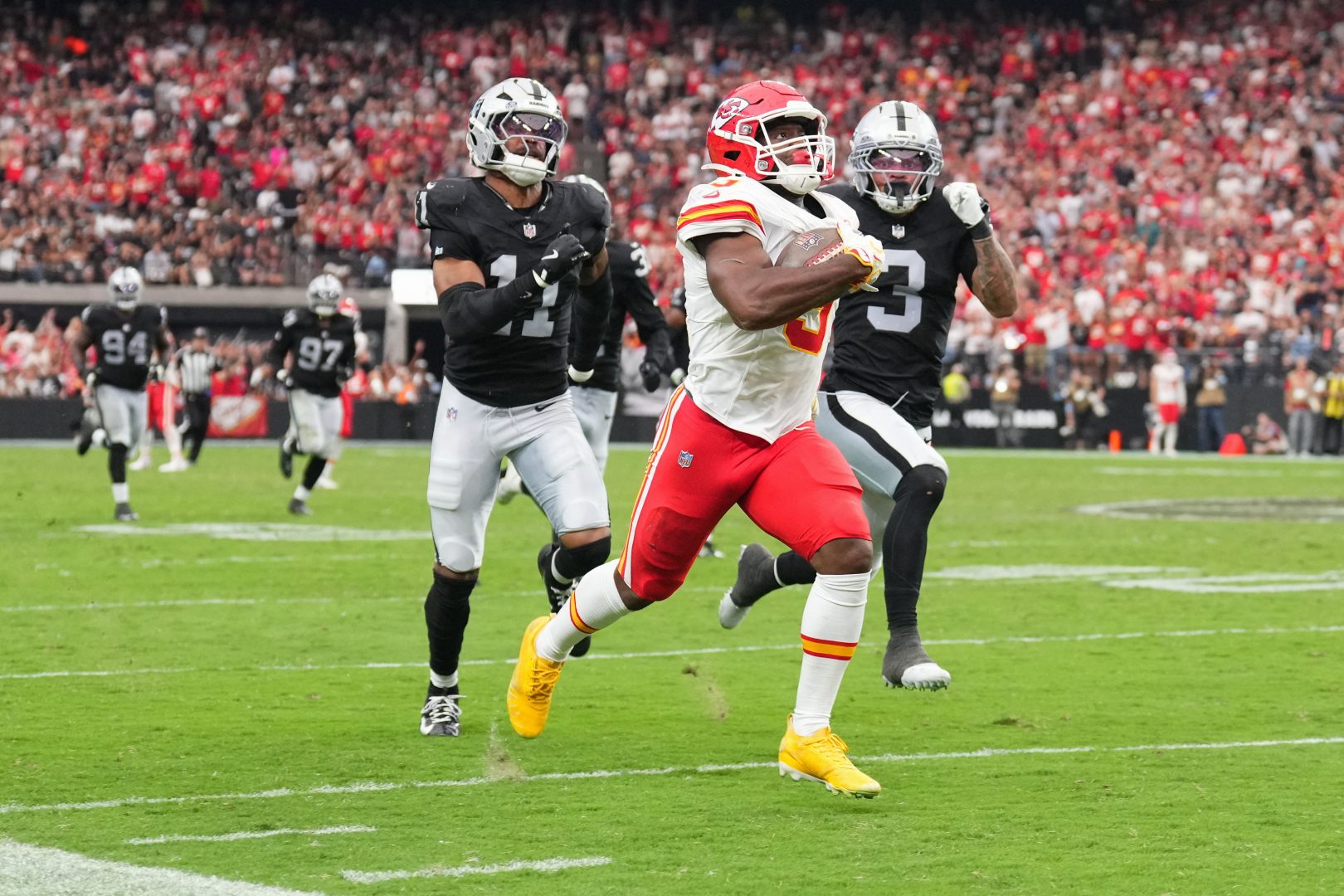 Kansas City Chiefs running back Kenneth Walker III breaks free for a 76-yard run against Las Vegas Raiders defenders Taron Johnson and Jeremy Chinn